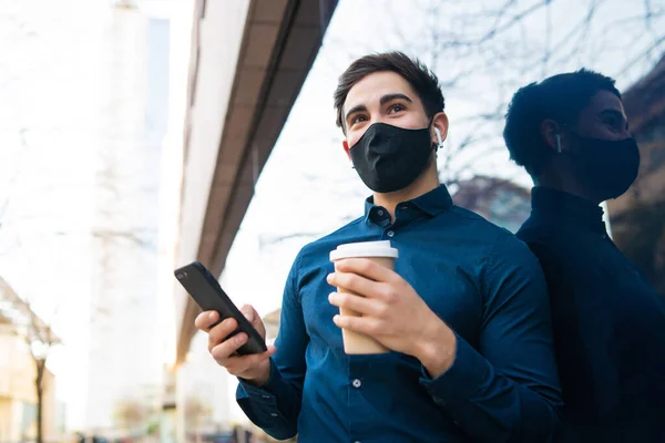 Young man using his mobile phone outdoors.