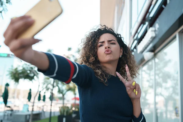 Νεαρή γυναίκα που παίρνει selfies με ένα κινητό τηλέφωνο στο ύπαιθρο. — Φωτογραφία Αρχείου