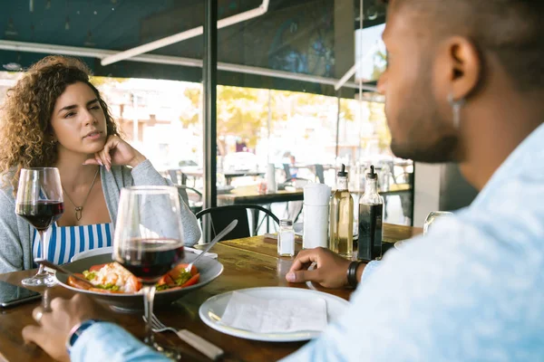 Et par som har en date på en restaurant. – stockfoto