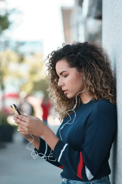 Mujer joven usando su teléfono móvil al aire libre en la calle. —  Fotos de Stock