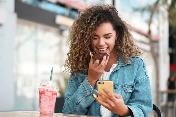 Mujer latina usando un teléfono móvil mientras está sentada en una cafetería. —  Fotos de Stock