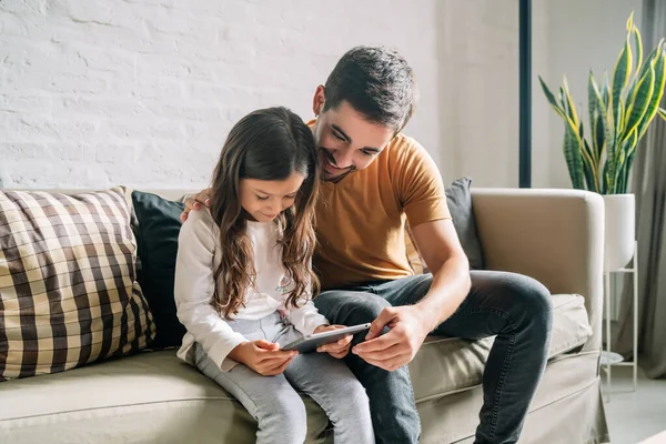Μικρό κορίτσι και ο πατέρας της χρησιμοποιώντας ένα ψηφιακό tablet στο σπίτι. — Φωτογραφία Αρχείου