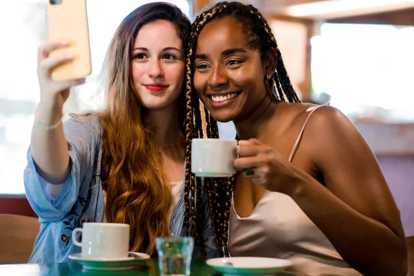 Freundinnen machen ein Selfie mit dem Handy in einem Café. — Stockfoto