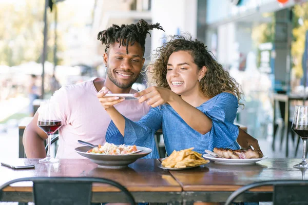 Coppia scattare foto al cibo con un telefono cellulare. — Foto Stock