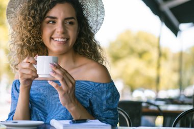 Kahve dükkanında kahve içen bir kadın..