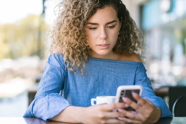 Mujer usando un teléfono móvil en una cafetería. —  Fotos de Stock