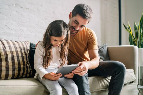 Μικρό κορίτσι και ο πατέρας της χρησιμοποιώντας ένα ψηφιακό tablet στο σπίτι. — Φωτογραφία Αρχείου