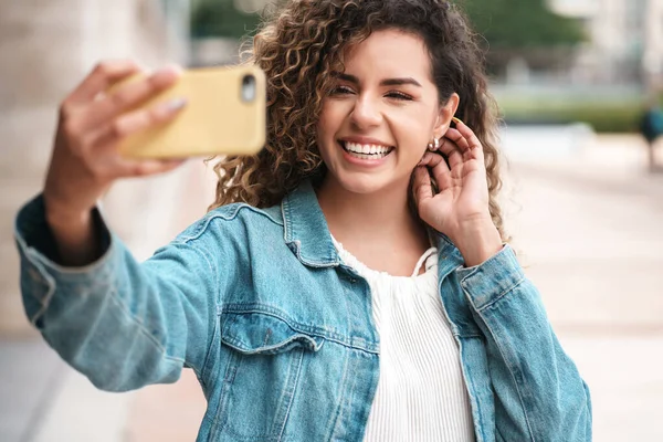 Νεαρή γυναίκα που βγάζει selfies με το κινητό της τηλέφωνο έξω. — Φωτογραφία Αρχείου