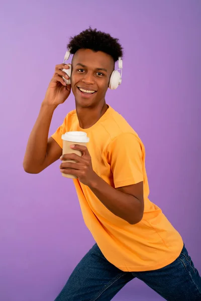 Jeune homme afro écouter de la musique avec des écouteurs. — Photo