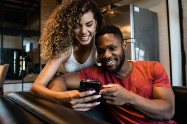 Evde cep telefonu kullanan genç bir çift..