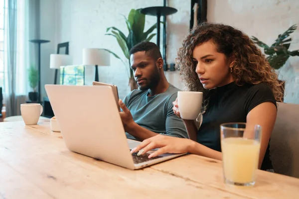 Coppia utilizzando laptop e tablet digitale a casa. — Foto Stock