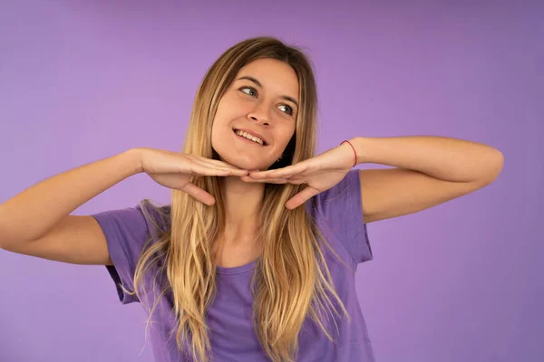 Retrato de una mujer joven sonriendo mientras está de pie sobre un fondo aislado. — Foto de Stock