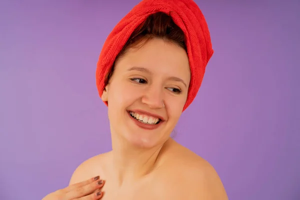 Młoda kobieta uśmiechnięta ręcznikiem na głowie. — Zdjęcie stockowe