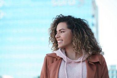 Sokakta dikilen Latin kadın gülümsüyor..