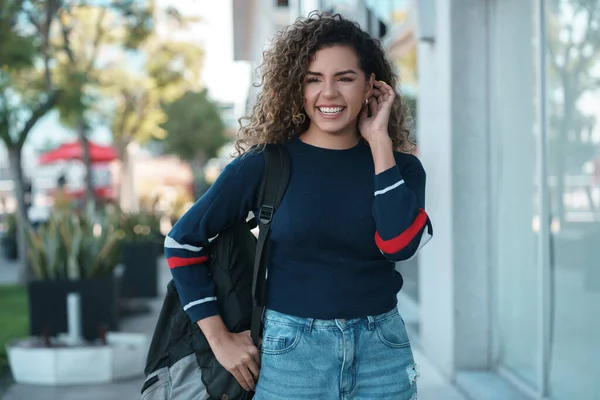 Femme latine souriant tout en marchant à l'extérieur dans la rue. — Photo