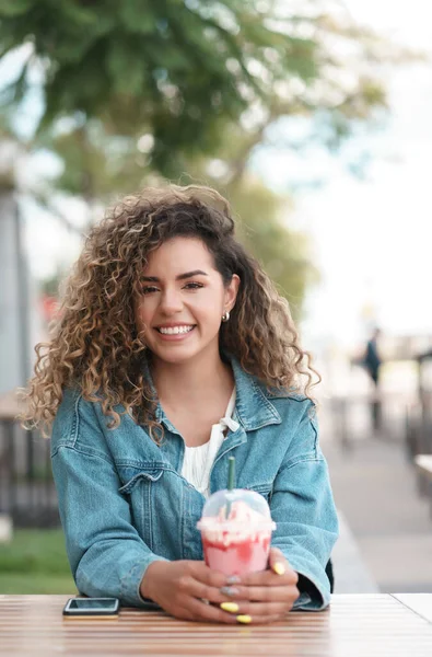 Jeune femme buvant une boisson fraîche dans un café. — Photo