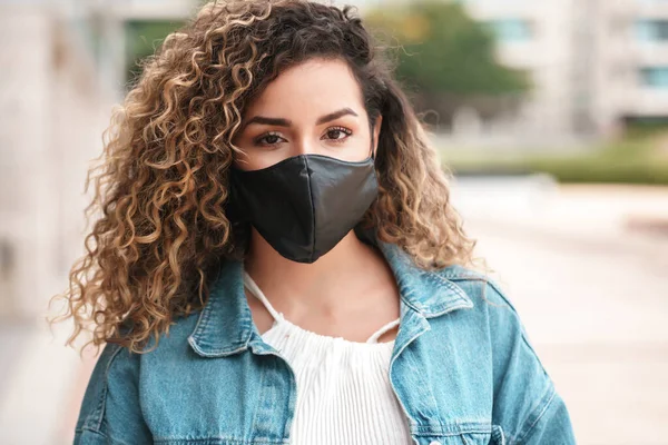 Mulher latina usando uma máscara facial ao ar livre. — Fotografia de Stock