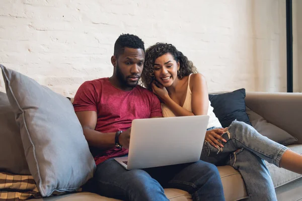 Pareja joven usando un ordenador portátil juntos en casa. —  Fotos de Stock