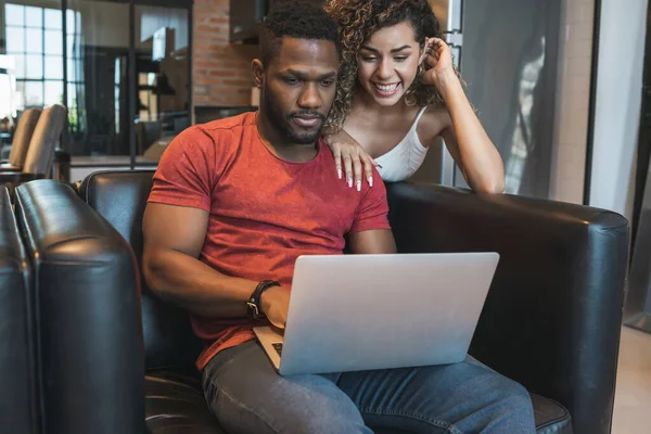 Giovane coppia utilizzando un computer portatile insieme a casa. — Foto Stock