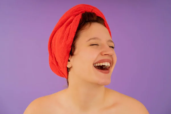 Mujer joven sonriendo mientras lleva una toalla en la cabeza. — Foto de Stock