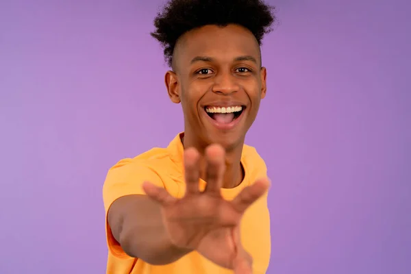 Junger Afro-Mann lächelt, um etwas mit der Hand zu fangen. — Stockfoto