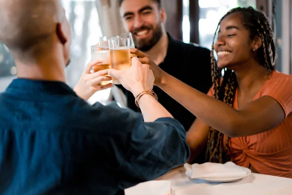 Gruppo di amici che brindano con bicchieri di birra in un ristorante. — Foto Stock