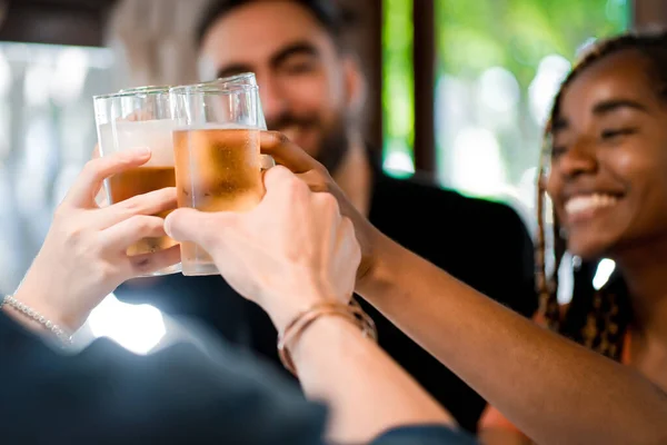 Amici che brindano con bicchieri di birra in un bar o pub. Foto Stock Royalty Free