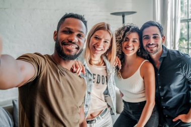 Bir grup arkadaş cep telefonuyla selfie çekiyor..