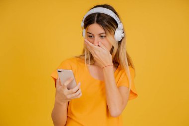 Genç bir kadın cep telefonundan şok olmuş gibi görünüyor..