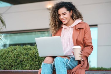 Latin kadın laptopunu açık havada kullanıyor..