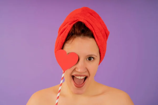 Mujer joven sonriendo mientras lleva una toalla en la cabeza. — Foto de Stock