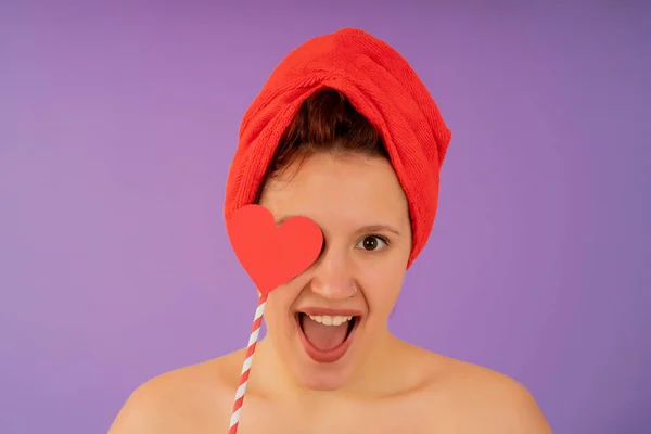 Giovane donna sorridente mentre indossa un asciugamano sulla testa. Immagine Stock