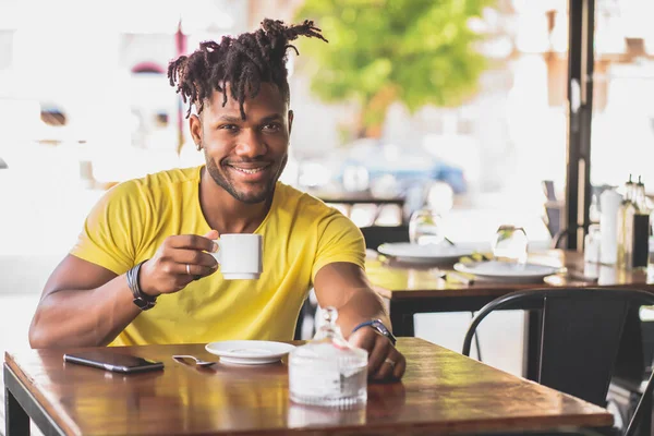 Hombre bebiendo una taza de café en una cafetería. — Foto de Stock