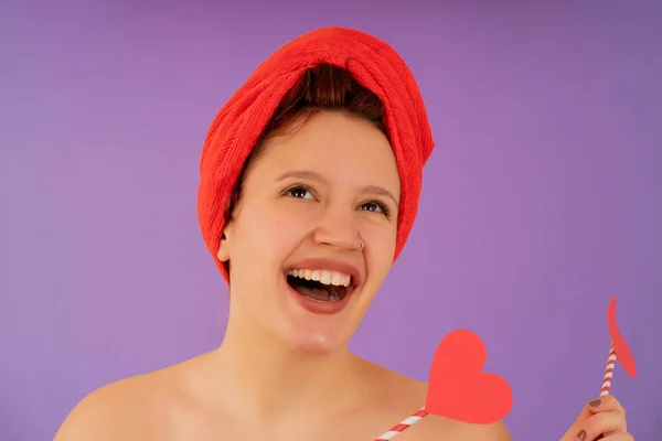 Mujer joven sonriendo mientras lleva una toalla en la cabeza. — Foto de Stock