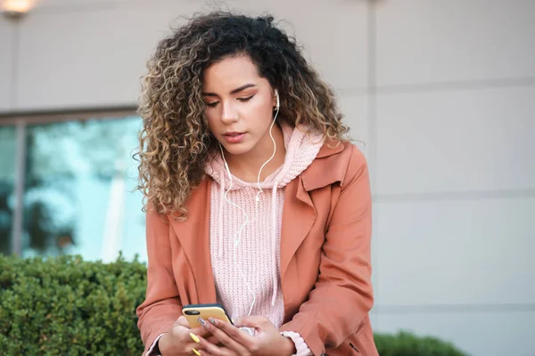 Mujer latina usando su teléfono móvil al aire libre. —  Fotos de Stock