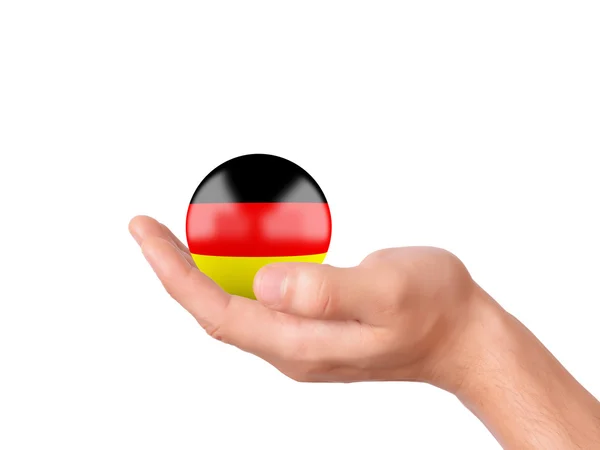 Mão segurar ícone bandeira da Alemanha no terreno de panificação branco — Fotografia de Stock