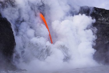 Hawaii 'deki uçurumdan okyanusa akan lavlar.