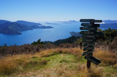 Wooden signpost in Queen Charlotte Track  showing distance to international cities around the World, New Zealand clipart