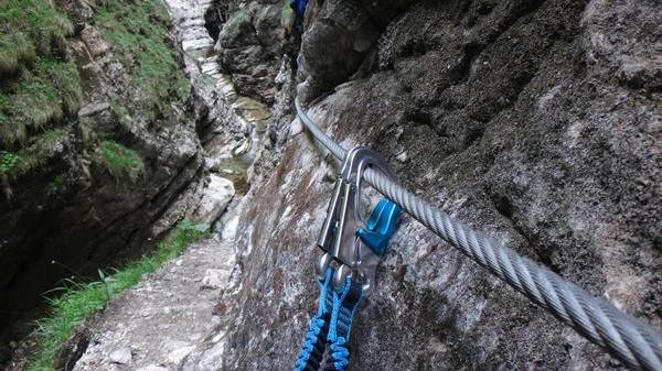 Snap hook on steel rope in via ferrata in Austria