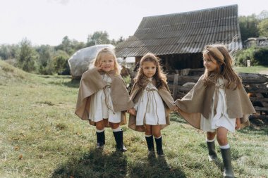 Beyaz bohem elbiseler içinde küçük köyde yürüyen sevimli küçük kızlar. 