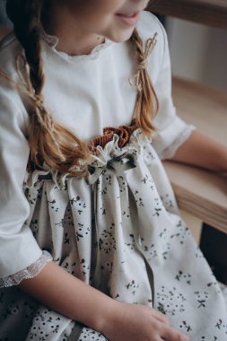 Noel arifesinde bohem beyaz çiçekli elbise giymiş güzel bir kız merdivenlerde oturuyor.