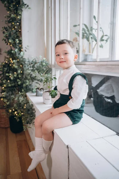 Χαριτωμένο Αγόρι Εορταστικά Ρούχα Κάθεται Στο Παράθυρο Και Κοιτάζοντας Την — Φωτογραφία Αρχείου