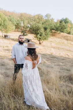 Kırsaldaki güzel çift, beyaz elbiseli yakışıklı sakallı adam ve kadın. 