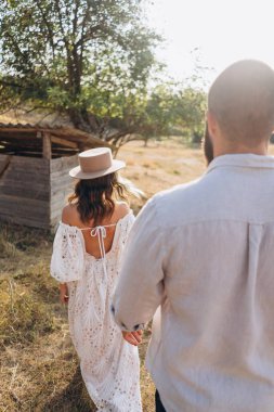 Kırsaldaki güzel çift, beyaz elbiseli yakışıklı sakallı adam ve kadın. 