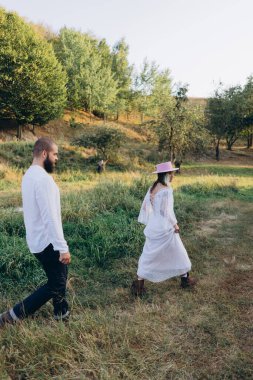 Kırsaldaki güzel çift, beyaz elbiseli yakışıklı sakallı adam ve kadın. 