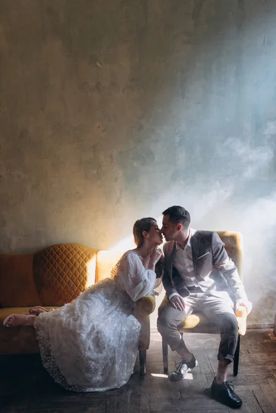 양복을 남자가 의자에 아름다운 관능적 드레스를 여자가 연기가 앞에서 키스하는 — 스톡 사진