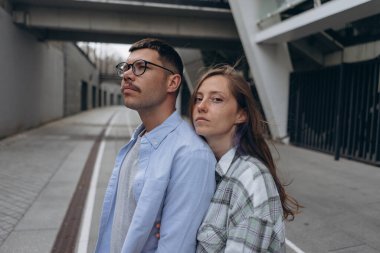 Genç bir çiftin sokakta birbirini nazikçe kucakladığı bir fotoğraf.