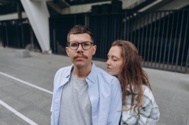 Genç bir çiftin sokakta birbirini nazikçe kucakladığı bir fotoğraf.