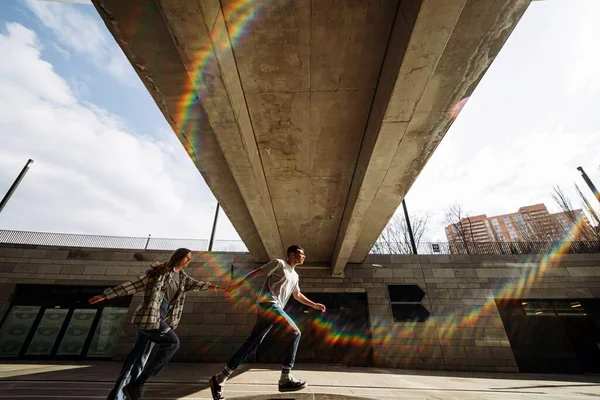 Foto Jovem Casal Iluminado Pelo Sol Correndo Estrada Cidade — Fotografia de Stock