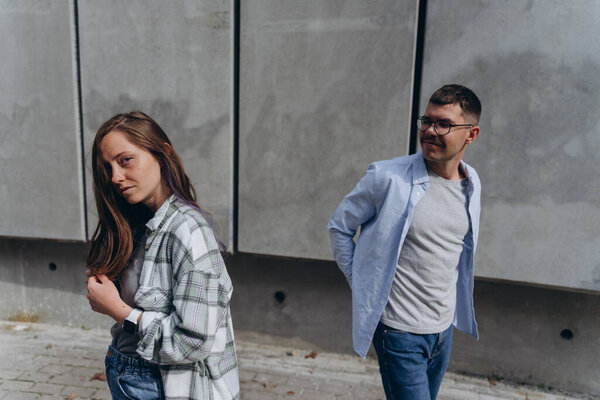photo of the young couple in love walking around the day city among skyscrapers 